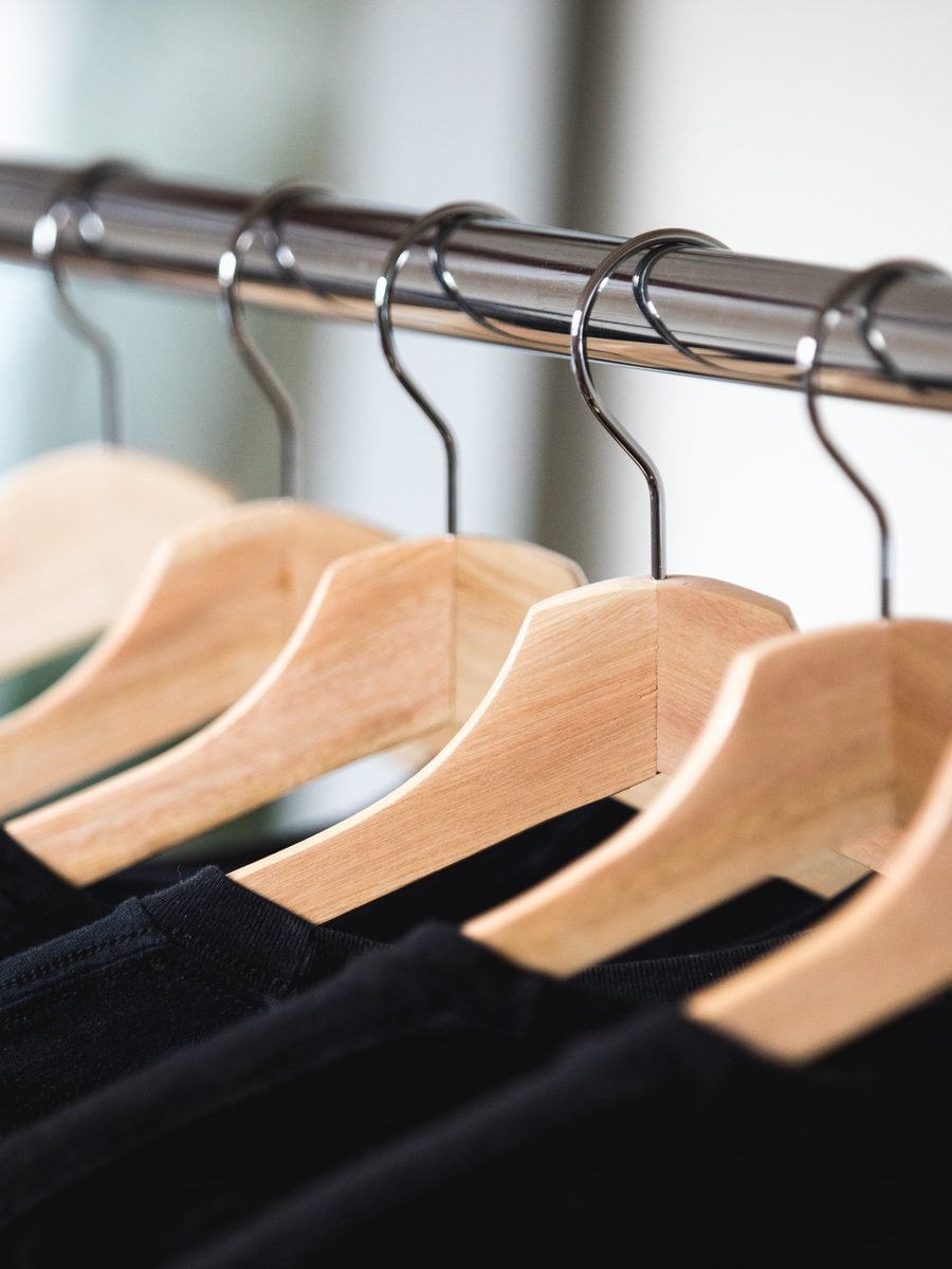 Wooden hangers holding finished black garments on a rail